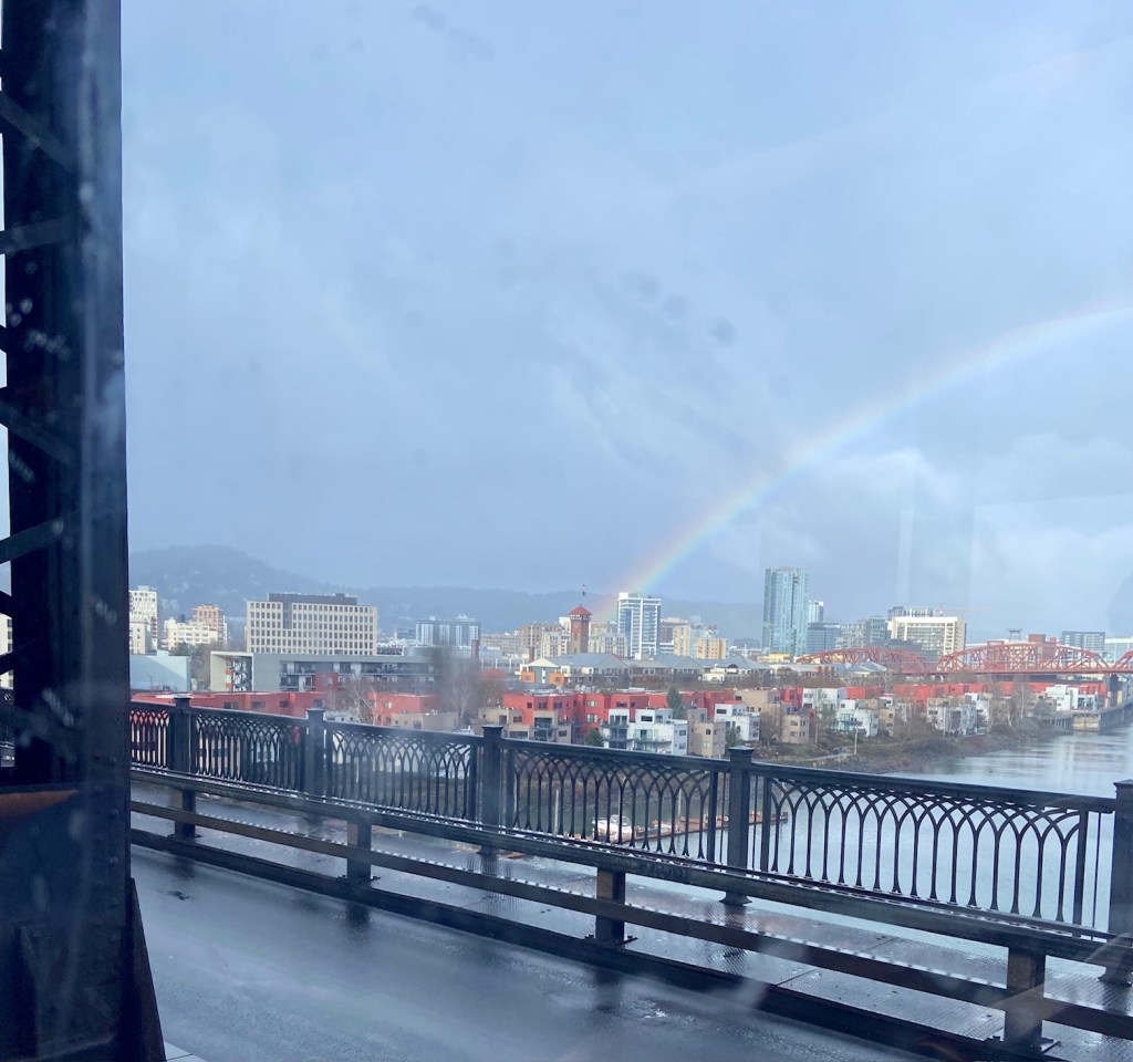 Downtown of city, it is raining and there is a rainbow